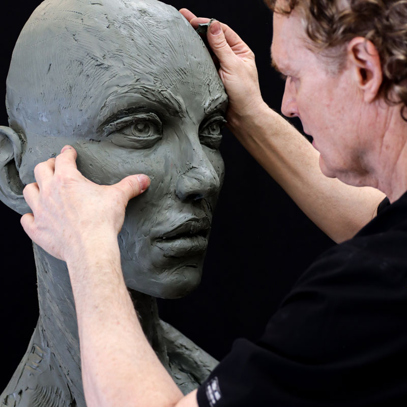 Dr. Schmid sculpting clay face